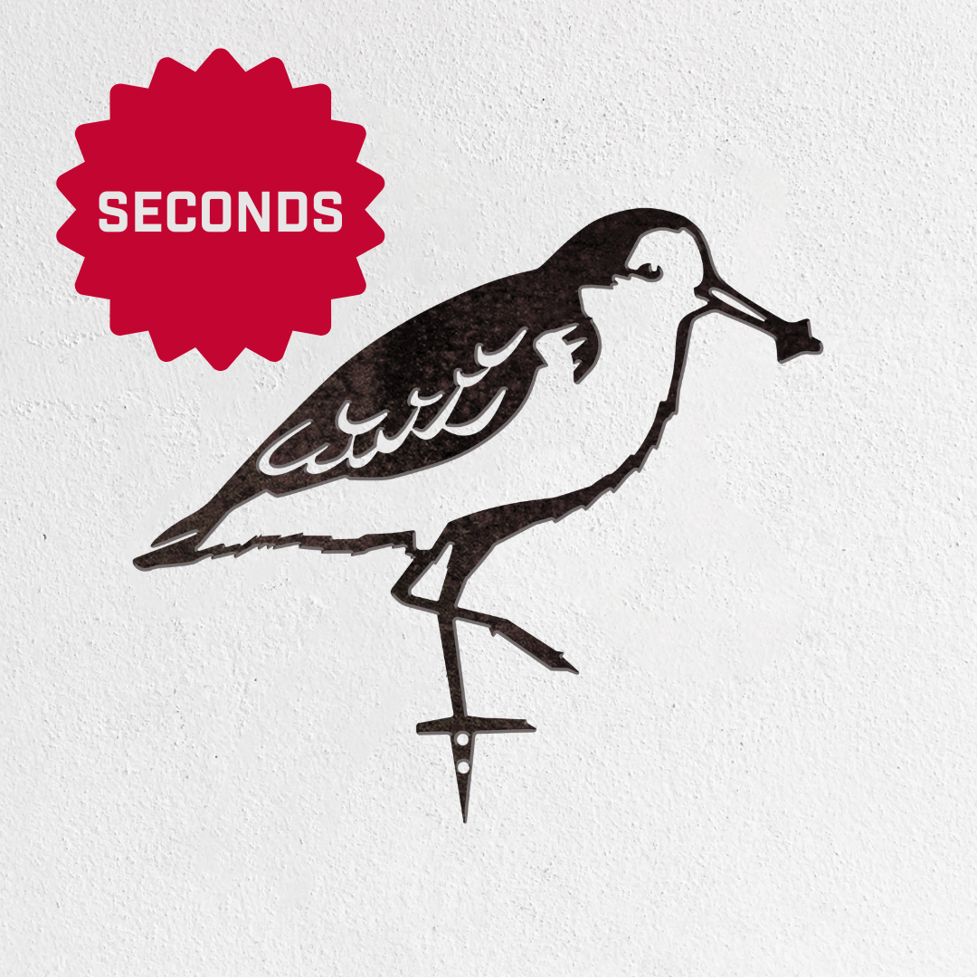 The Metalbird Seconds by Metalbird Canada - Seconds features a bird silhouette crafted from corten steel, mounted on a white wall. A red "SECONDS" starburst in the upper left marks this unique garden art as a charming gift option.