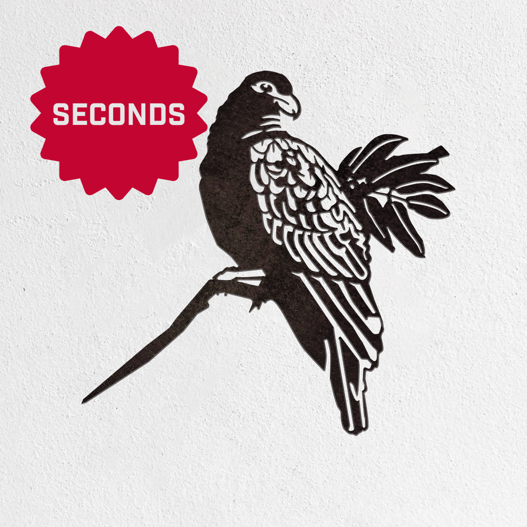 Metalbird Canada - Seconds: Metalbird Seconds black metal wall art features a parrot on a branch against white, ideal as unique garden art or a special gift. A red starburst marked “SECONDS” appears in the top left corner.
