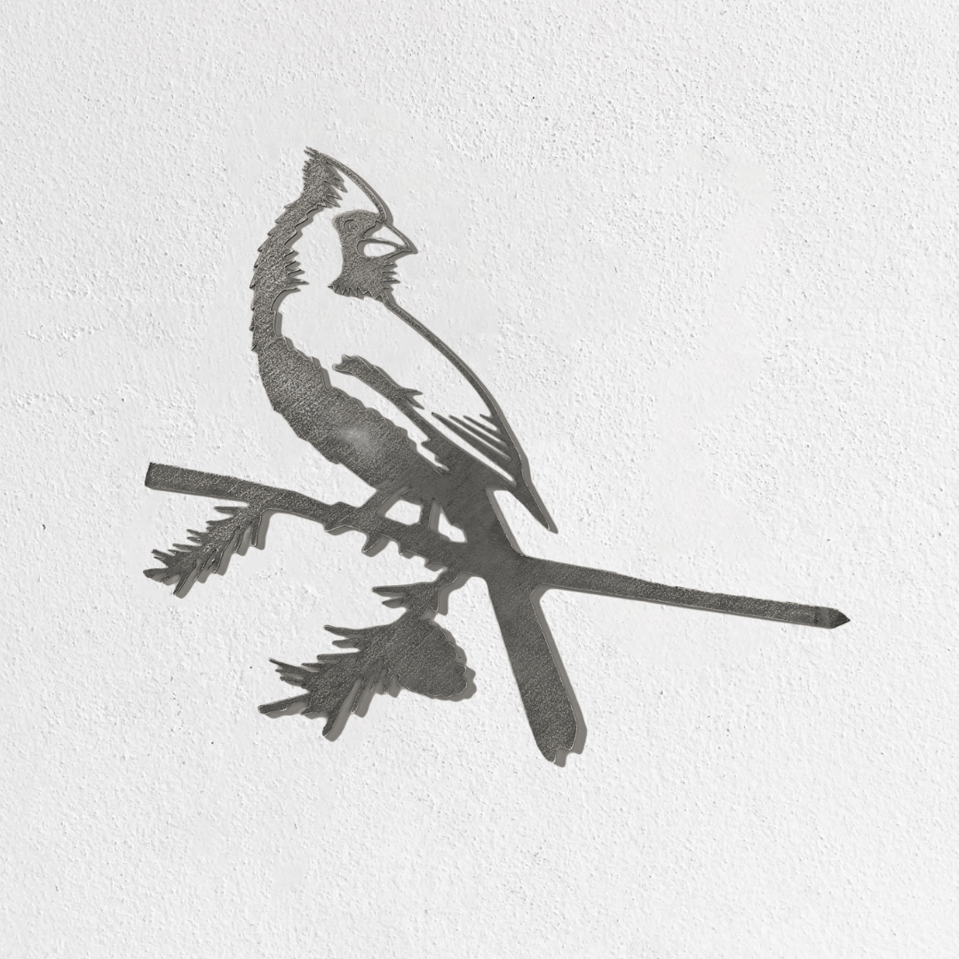 The Metalbird Seconds by Metalbird Canada - Seconds is a minimalist black-and-white metal cardinal silhouette perched on a branch, creating striking garden art when mounted on a textured white wall.