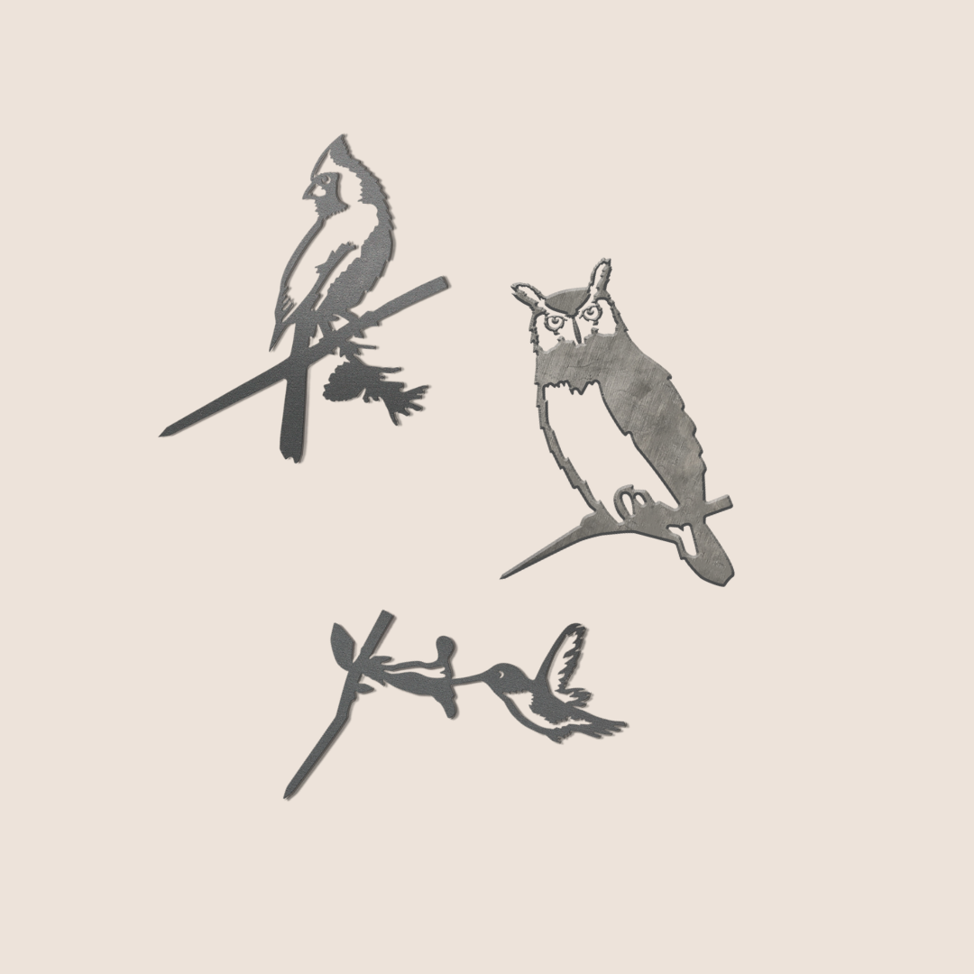 The Baby Bird Bundle by Metalbird Canada features three corten steel bird silhouettes—cardinal, owl, and hummingbird—that add charming accents to your garden, all set against a light beige background.