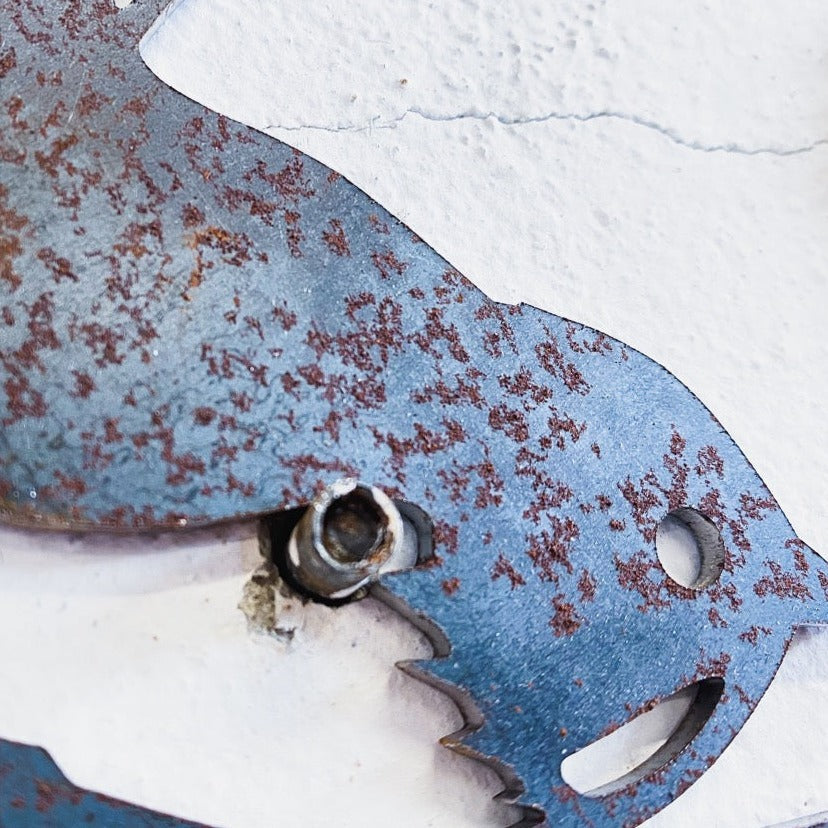 Close-up of Metalbird Canada - Seconds' Metalbird Seconds: a rusty, weathered corten steel cat-shaped wall decoration mounted on a white textured wall—an eye-catching garden art piece.