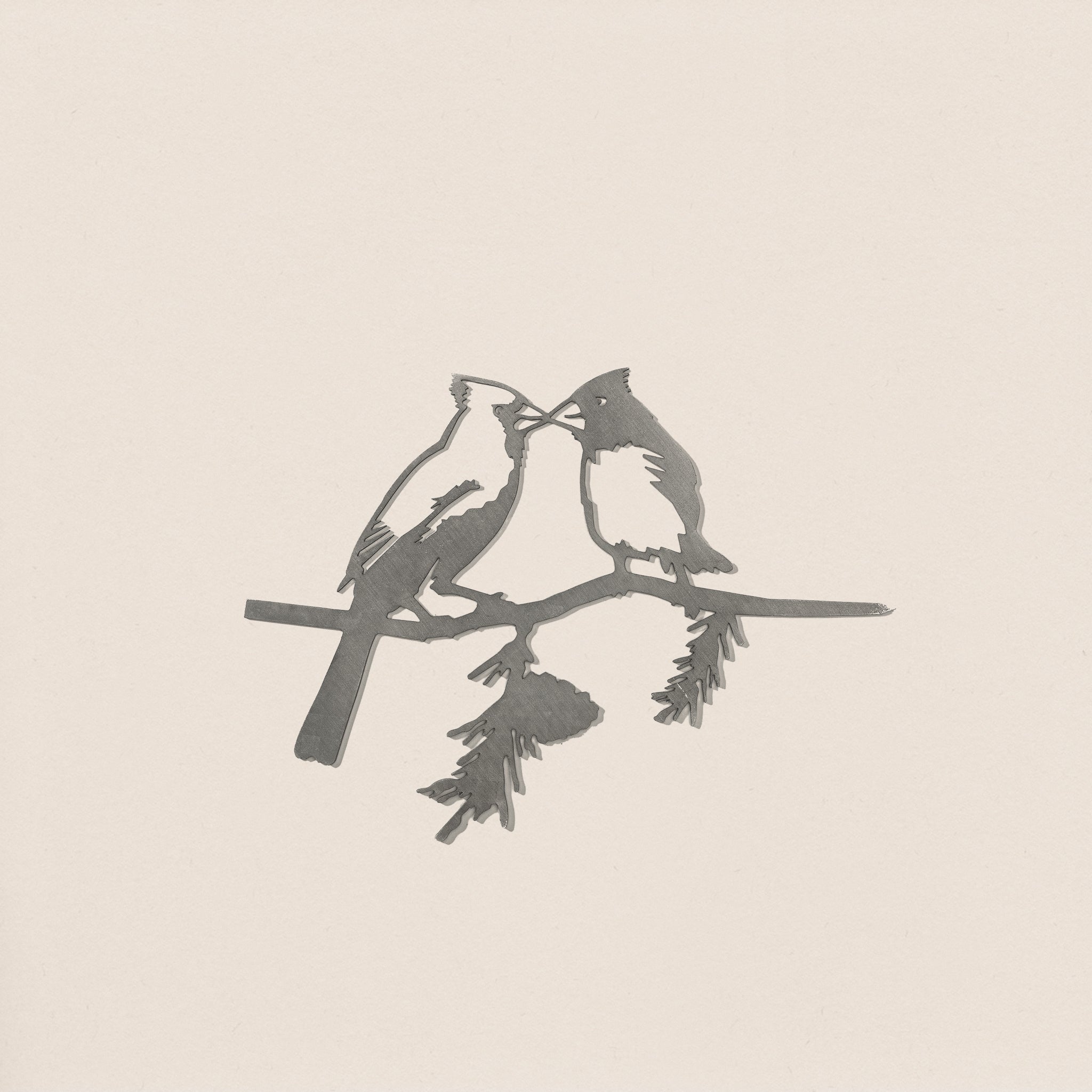 Kissing Cardinals by Metalbird Canada features a minimalist design of two cardinals perched together on a leafy branch, set against a light background—ideal inspiration for corten steel yard art.