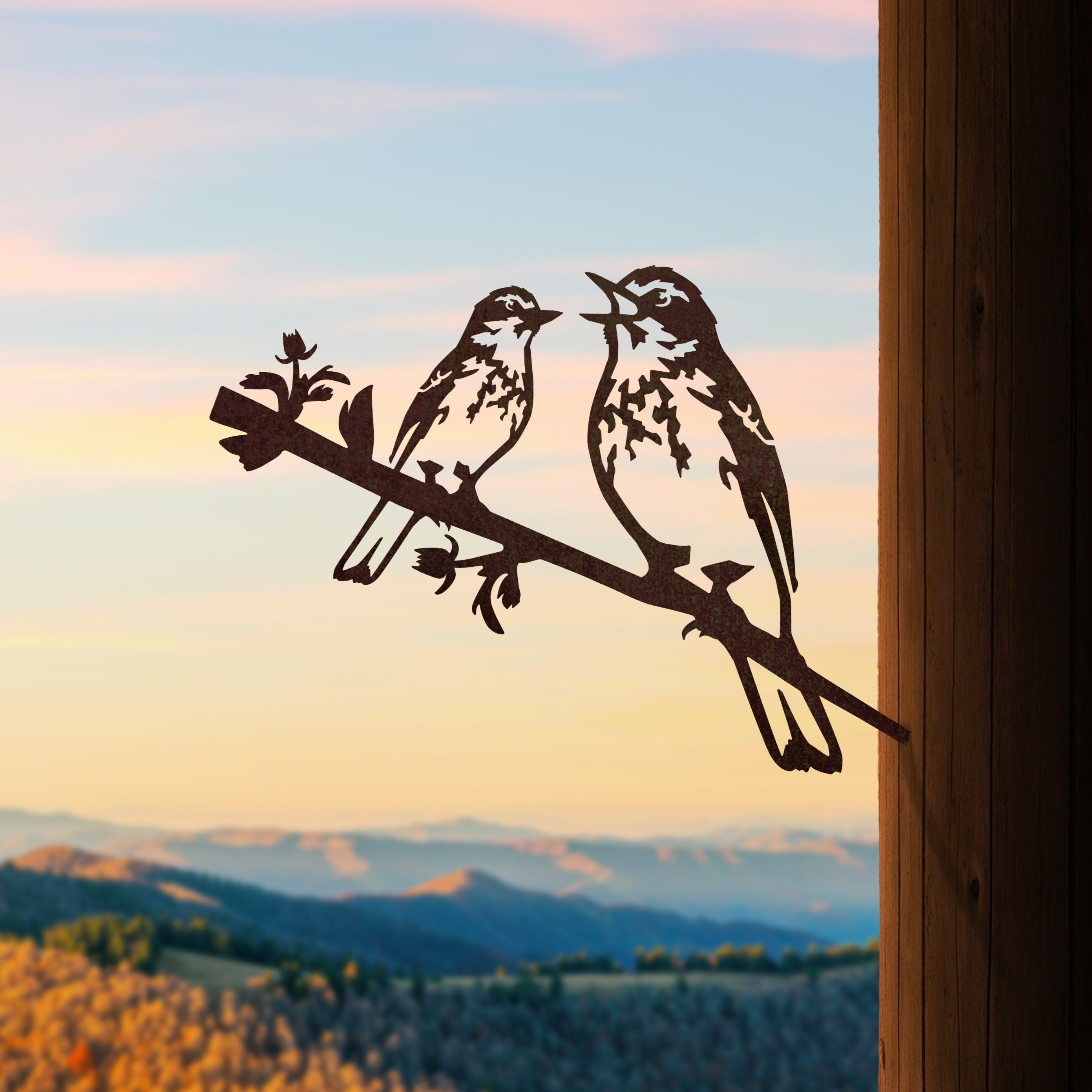 Pipit & Chick by Metalbird Canada features two birds perched on a branch in corten steel, mounted on a wooden post—perfect yard art with scenic hill views and sunset skies.