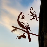 The Cardinal Mom & Mini Set by Metalbird Canada features two cardinal silhouettes on branches, set against a dreamy sky—an ideal gift for bird lovers.
