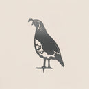The Quail by Metalbird Canada features a bold black and white silhouette of the bird with its iconic head plume, creating striking garden art on a light beige background.