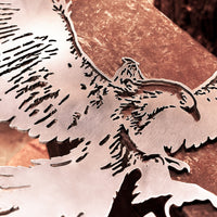 A close-up of GANDALF™ ON GWAIHIR™ by Metalbird Canada, a striking corten steel artwork with an eagle outline and sharp cut edges, displayed on a copper-toned surface as unique garden art.