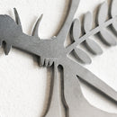 Close-up of Metalbird Seconds by Metalbird Canada - Seconds, a corten steel wall art piece featuring a stylized insect with wing and leaf details, mounted on white—ideal as unique garden decor.