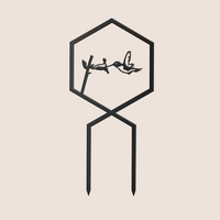 The Hummingbird Plant Trellis by Metalbird Canada is a minimalist black corten steel garden stake featuring a hexagon frame with a hummingbird silhouette near a flower, and two straight stakes for easy placement—ideal modern art for your garden.