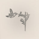 The Hummingbird by Metalbird Canada features a minimalist, monochrome design of a hummingbird feeding from a trumpet-shaped flower—ideal as metal yard art or a thoughtful gift.