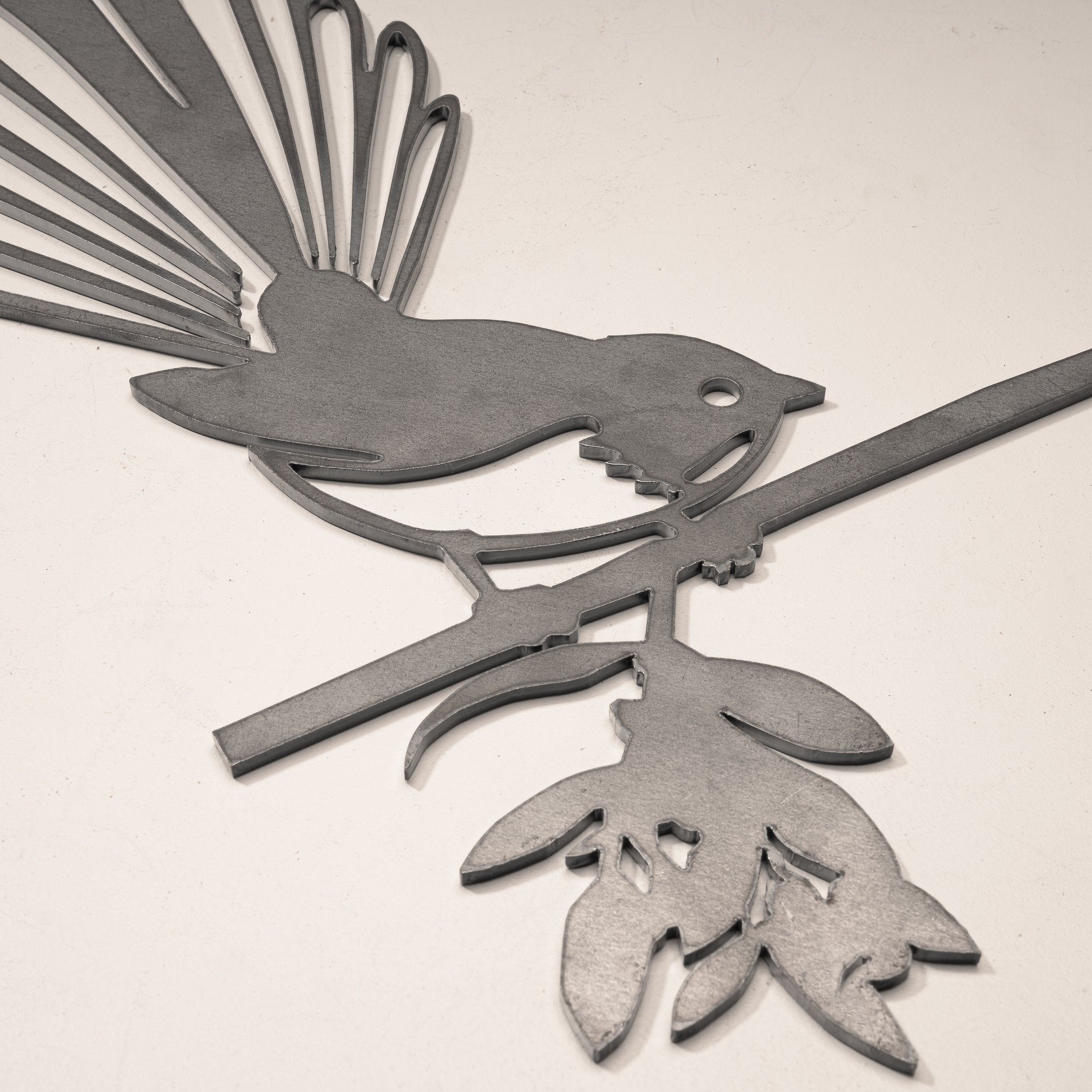 The Fantail / New Zealand Pīwakawaka by Metalbird Canada is a stunning metal silhouette of a bird on a leafy branch—ideal as unique garden art or a thoughtful gift.