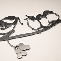 The Metalbird Canada "Chickadee & Chicks" black metal wall art features three birds on a leafy, berry-adorned branch—ideal as striking yard art or an elegant indoor accent.