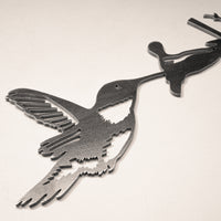 The Hummingbird by Metalbird Canada is a corten steel silhouette of a hummingbird feeding from a flower—ideal as unique garden art or a thoughtful gift, shown on a neutral background.