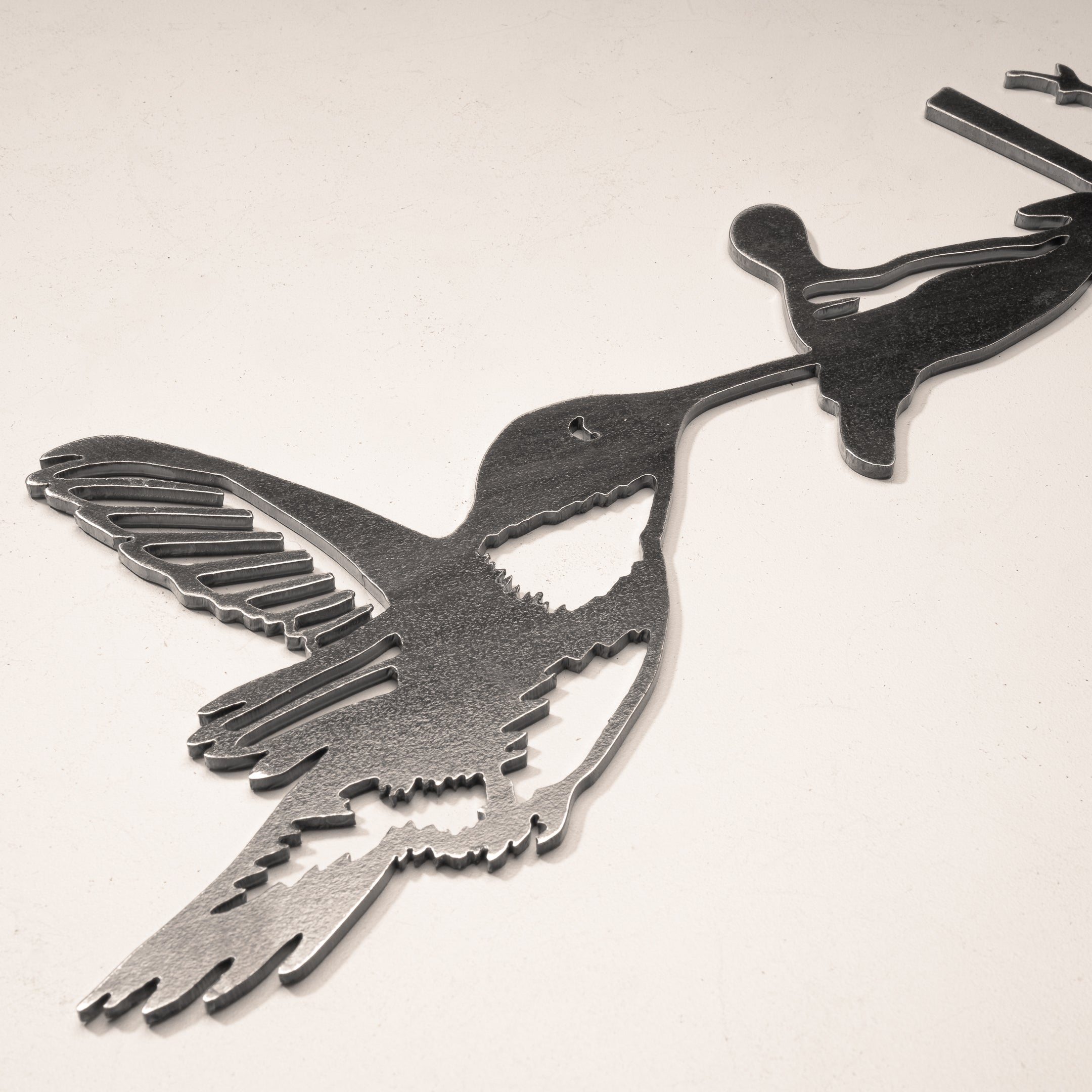 The Hummingbird by Metalbird Canada is a corten steel silhouette of a hummingbird feeding from a flower—ideal as unique garden art or a thoughtful gift, shown on a neutral background.