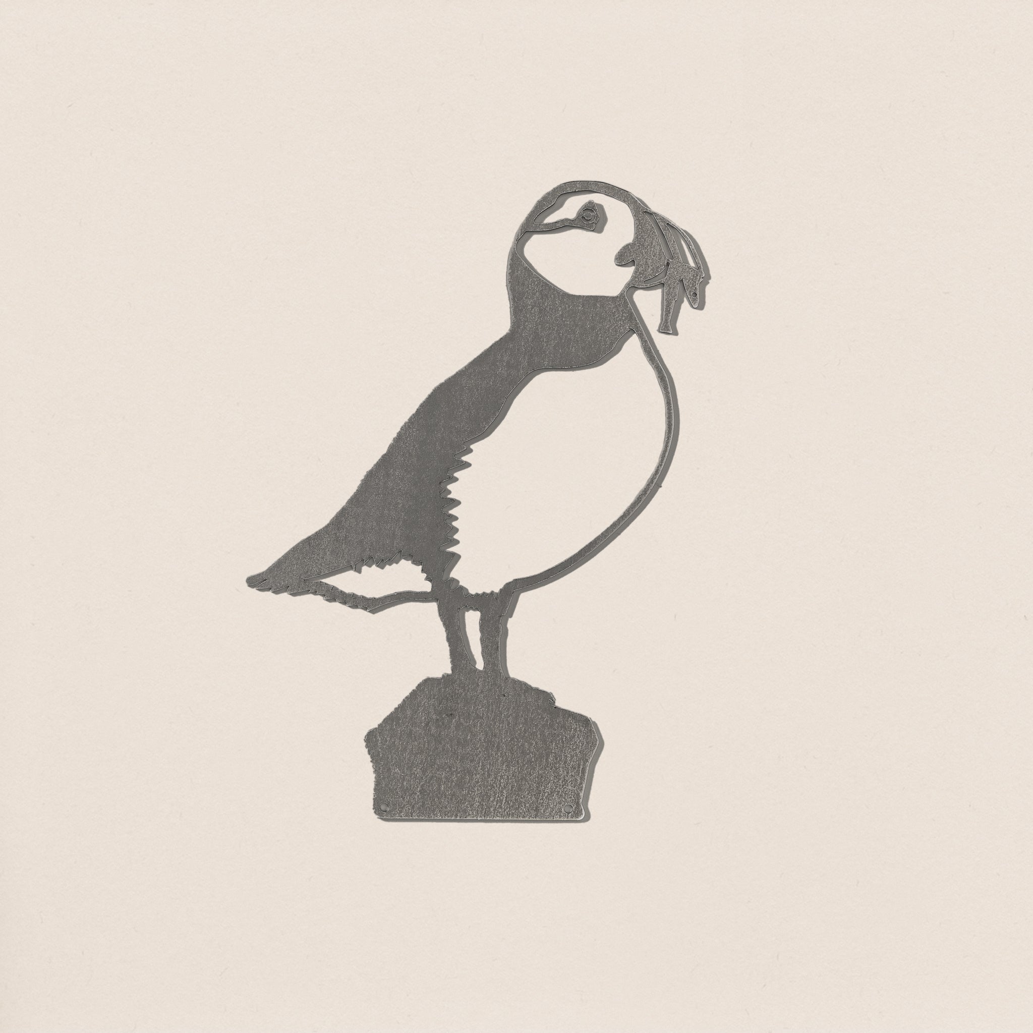 The Puffin by Metalbird Canada is a metal silhouette of a puffin standing on a rock, perfect as unique garden art or a thoughtful gift for nature lovers.