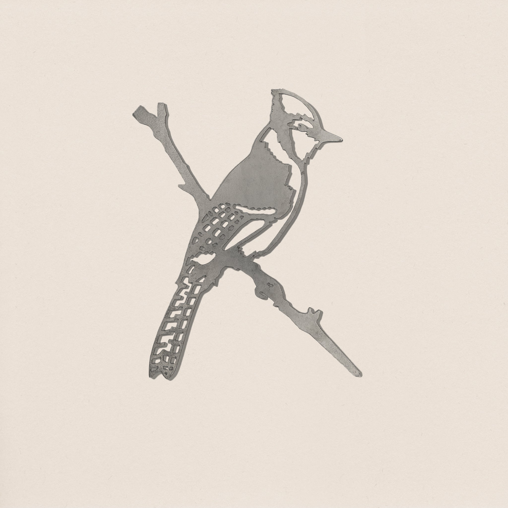Blue Jay by Metalbird Canada: a simple grayscale line drawing of a jay with a distinct crest and patterned tail perched on a thin branch against an off-white background—an elegant silhouette, perfect as a gift.