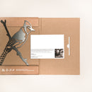 Blue Jay by Metalbird Canada: A brown cardboard folder with a metallic blue jay on a branch, inspired by corten steel, includes a white card with printed text and photo—a distinctive and memorable gift.