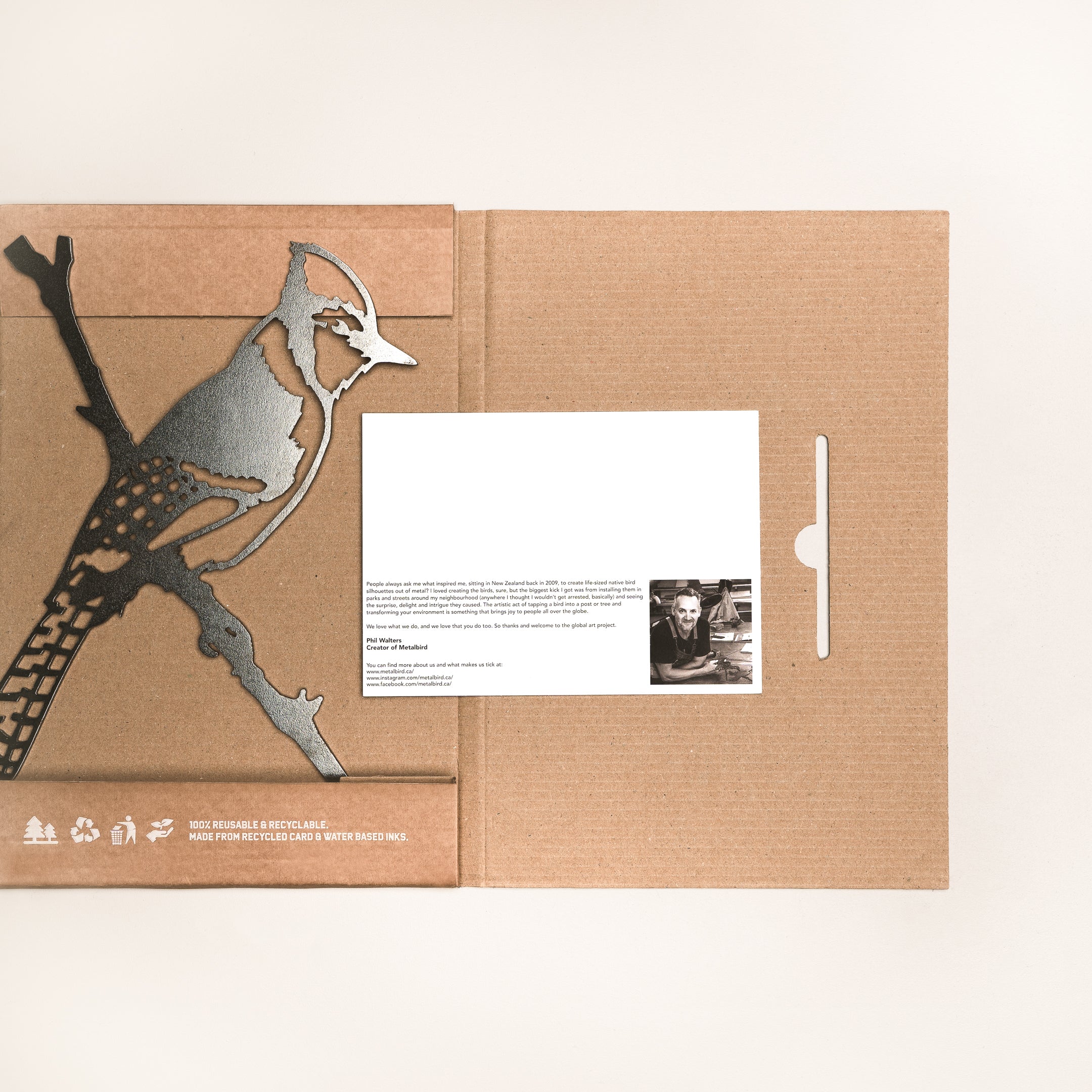 Blue Jay by Metalbird Canada: A brown cardboard folder with a metallic blue jay on a branch, inspired by corten steel, includes a white card with printed text and photo—a distinctive and memorable gift.