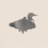 The Common Loon by Metalbird Canada is a corten steel cutout showing a loon with a chick on its back. With etched feather and face details, it’s perfect as unique garden art, displayed on a light background.