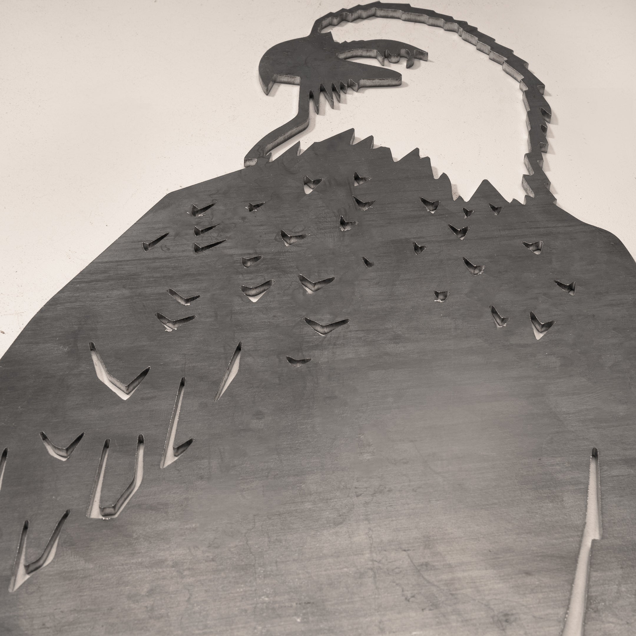 A large metal cutout of a Bald Eagle from Metalbird Canada, viewed from below, displays detailed head and feathers against a plain background—ideal as unique garden art or eye-catching yard decor.
